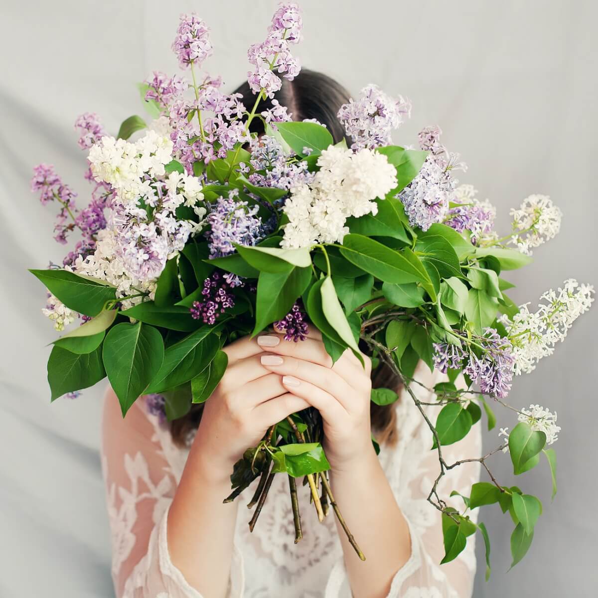結婚式で顔を花束で隠している様子の花嫁。