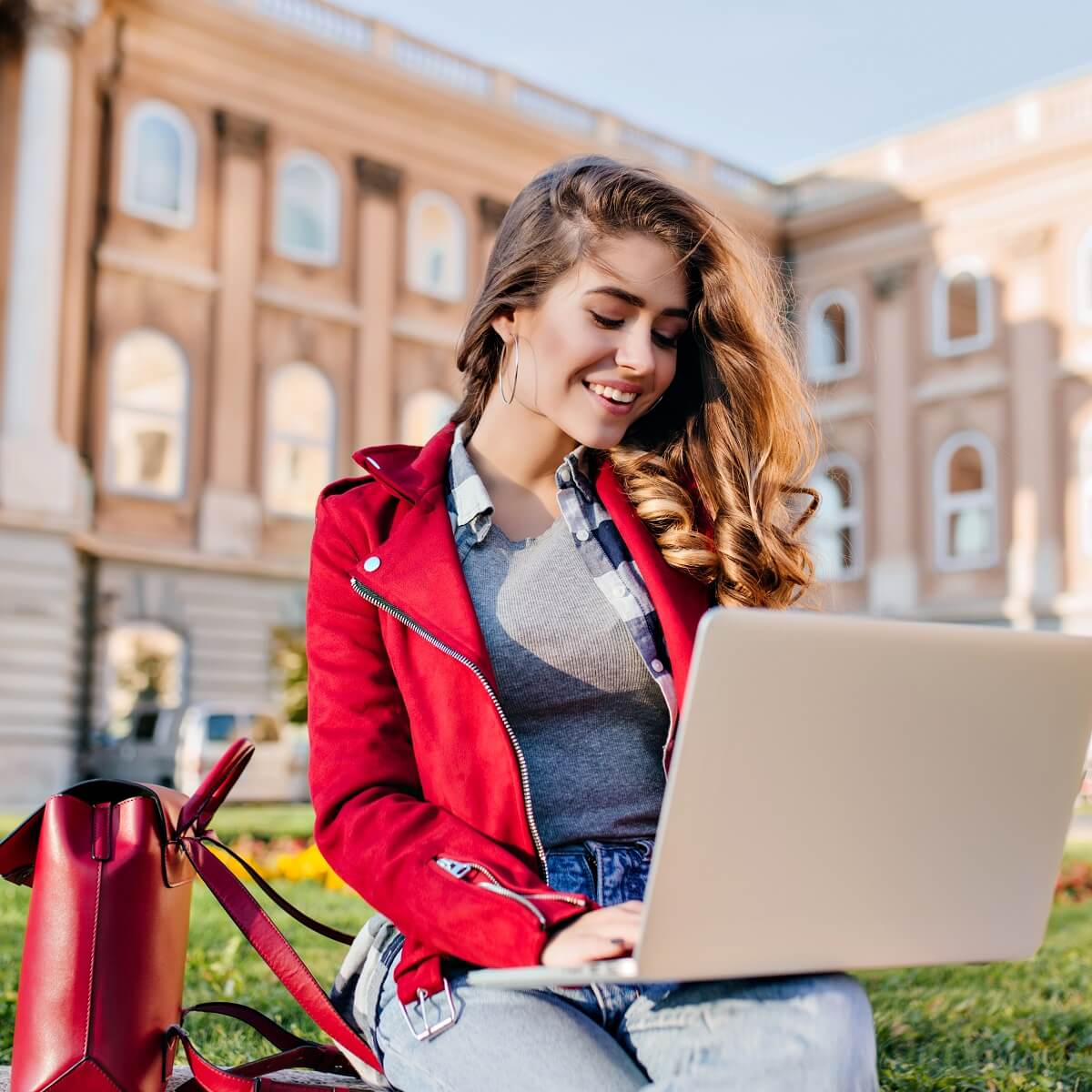 大学のキャンパスでノートパソコンを触っている女性の様子。